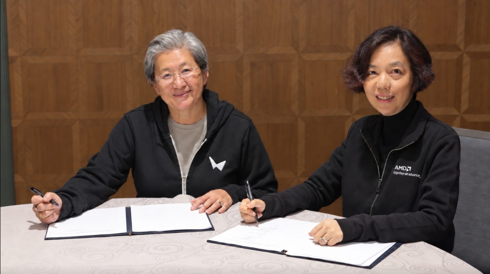 Lisa Su, CEO da AMD, e Fei-Fei Li assinam o acordo de aquisição da World Labs