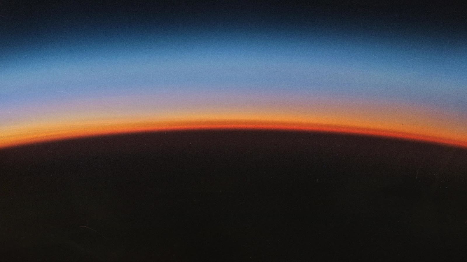 Arte oficial do lançamento com um horizonte em tons de azul e laranja
