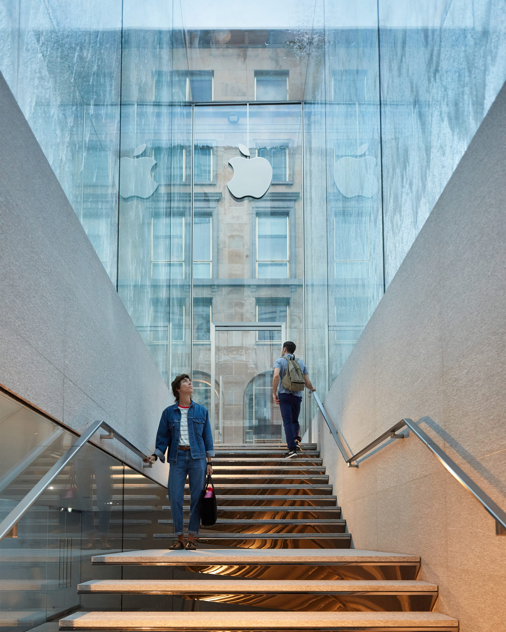 Escadaria da Apple Piazza Liberty, em Milão, com a cascata de vidro ao fundo