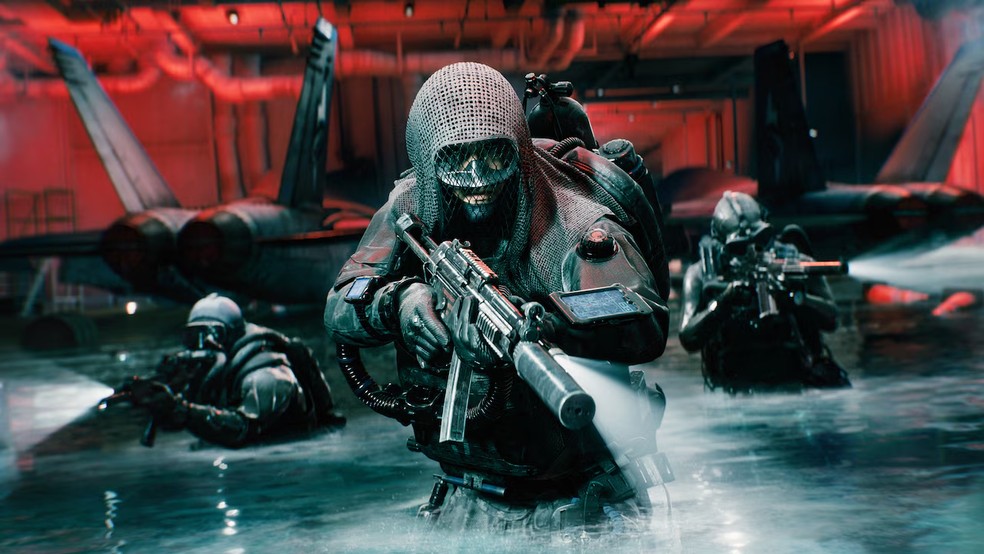 Soldados com equipamento de mergulho avançam pela água dentro de um hangar em Battlefield 6