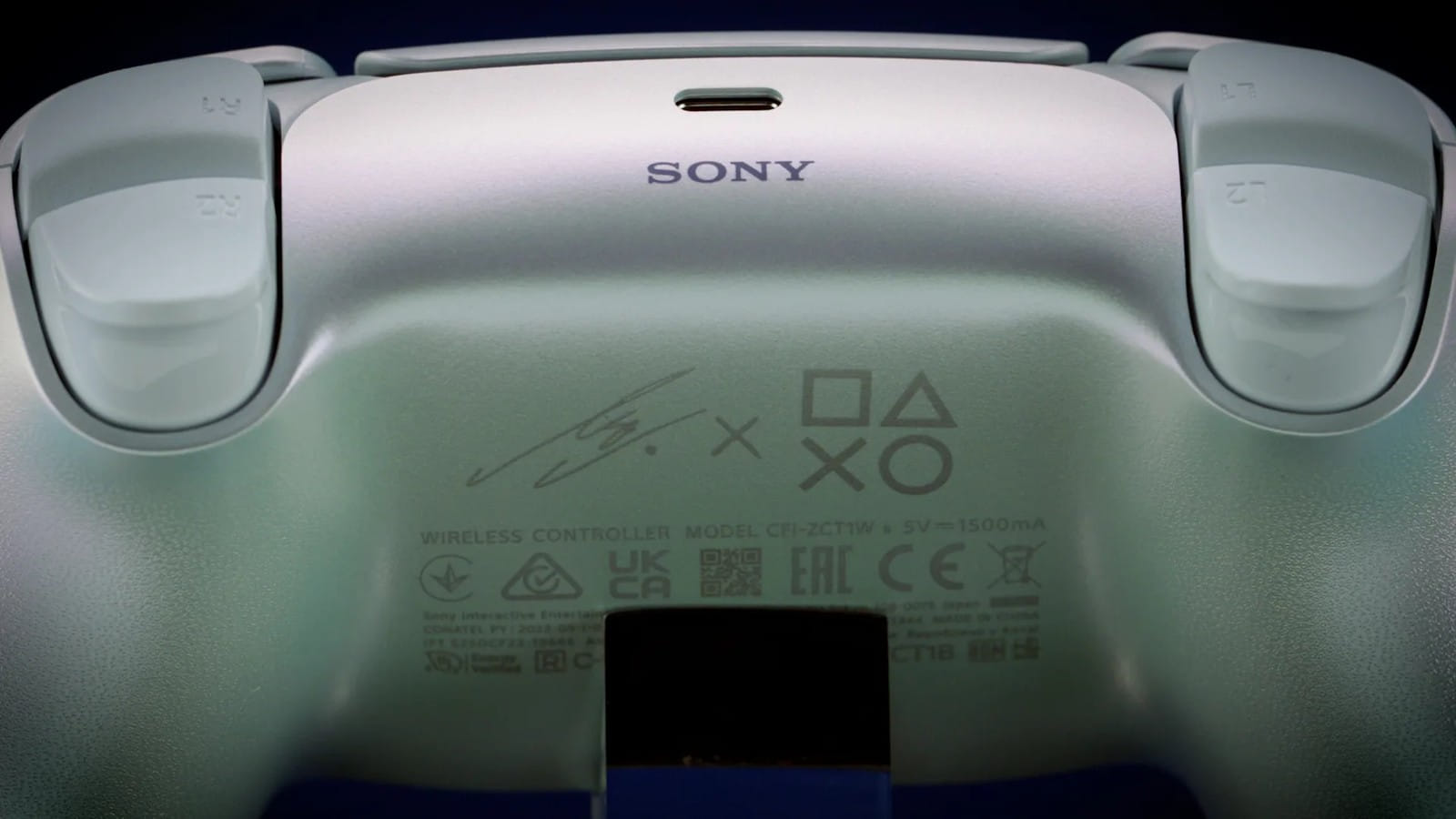 Parte traseira do controle com a assinatura da cantora ao lado dos símbolos do PlayStation