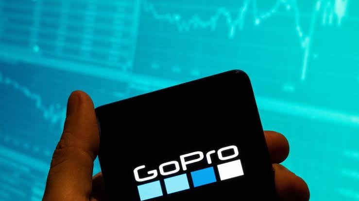 Logo da GoPro em um celular sobre um gráfico de ações