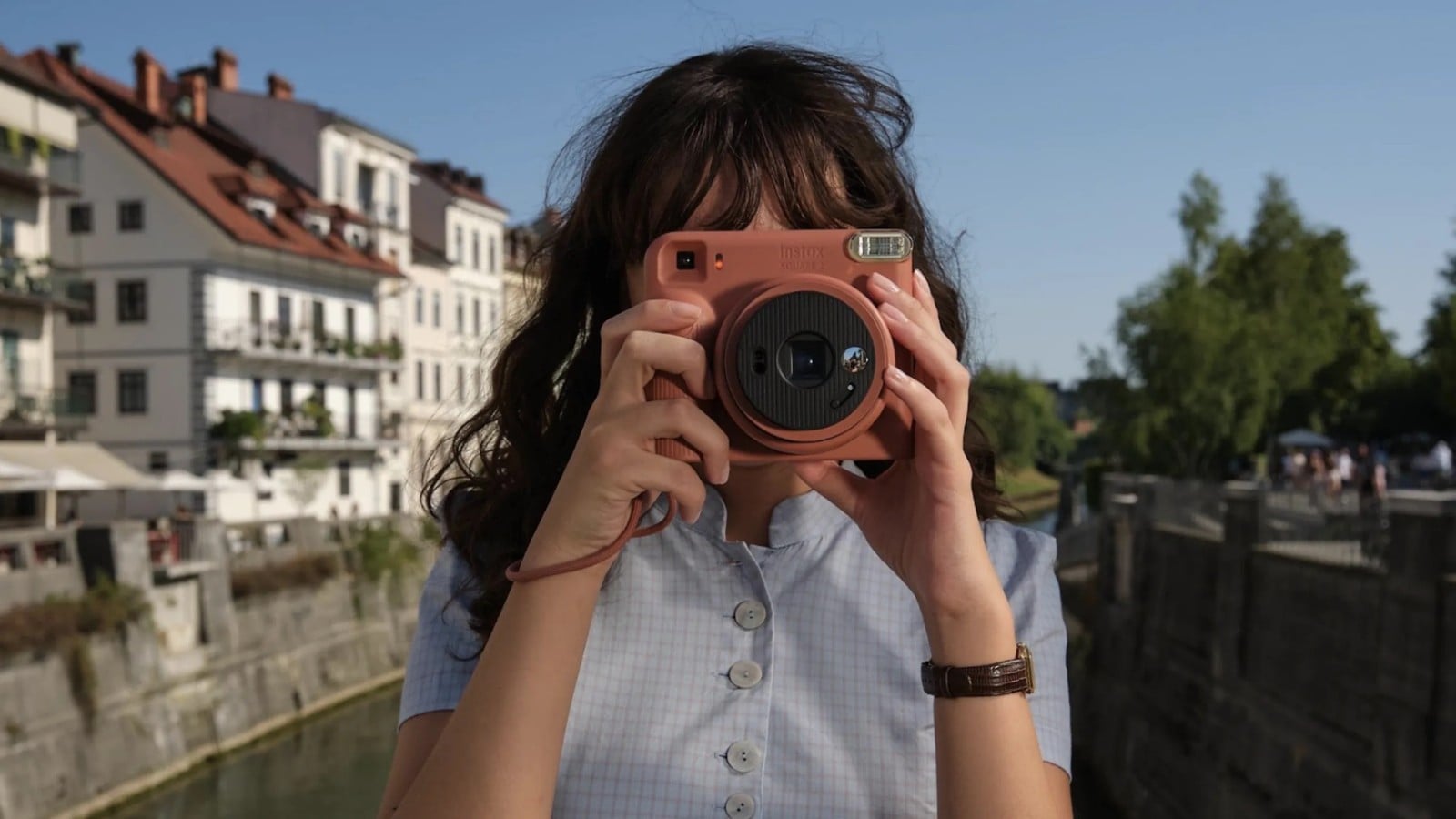 Mulher fotografando com a Instax SQUARE 2 vermelha