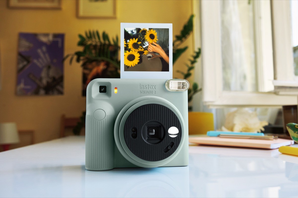 Instax SQUARE 2 na cor verde-acinzentada com uma foto impressa