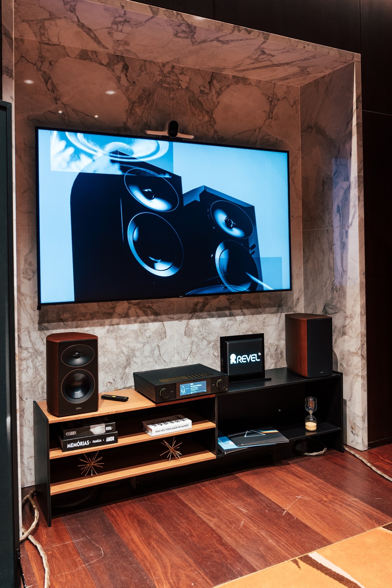 Ambiente de home theater da Revel com caixa central e caixas de estante sob a TV