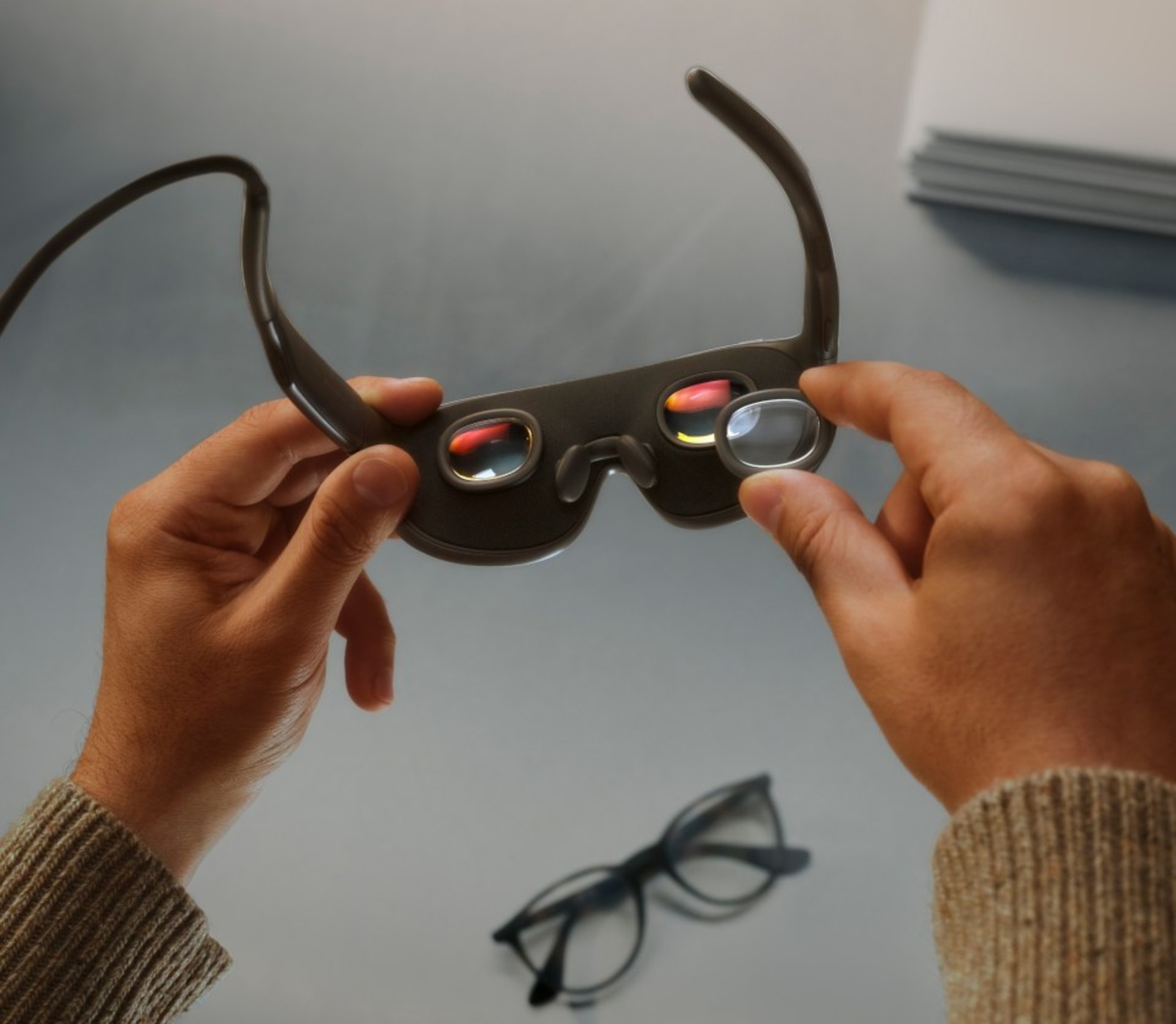 Meta VR Glasses nas mãos, ao lado de um par de óculos comum