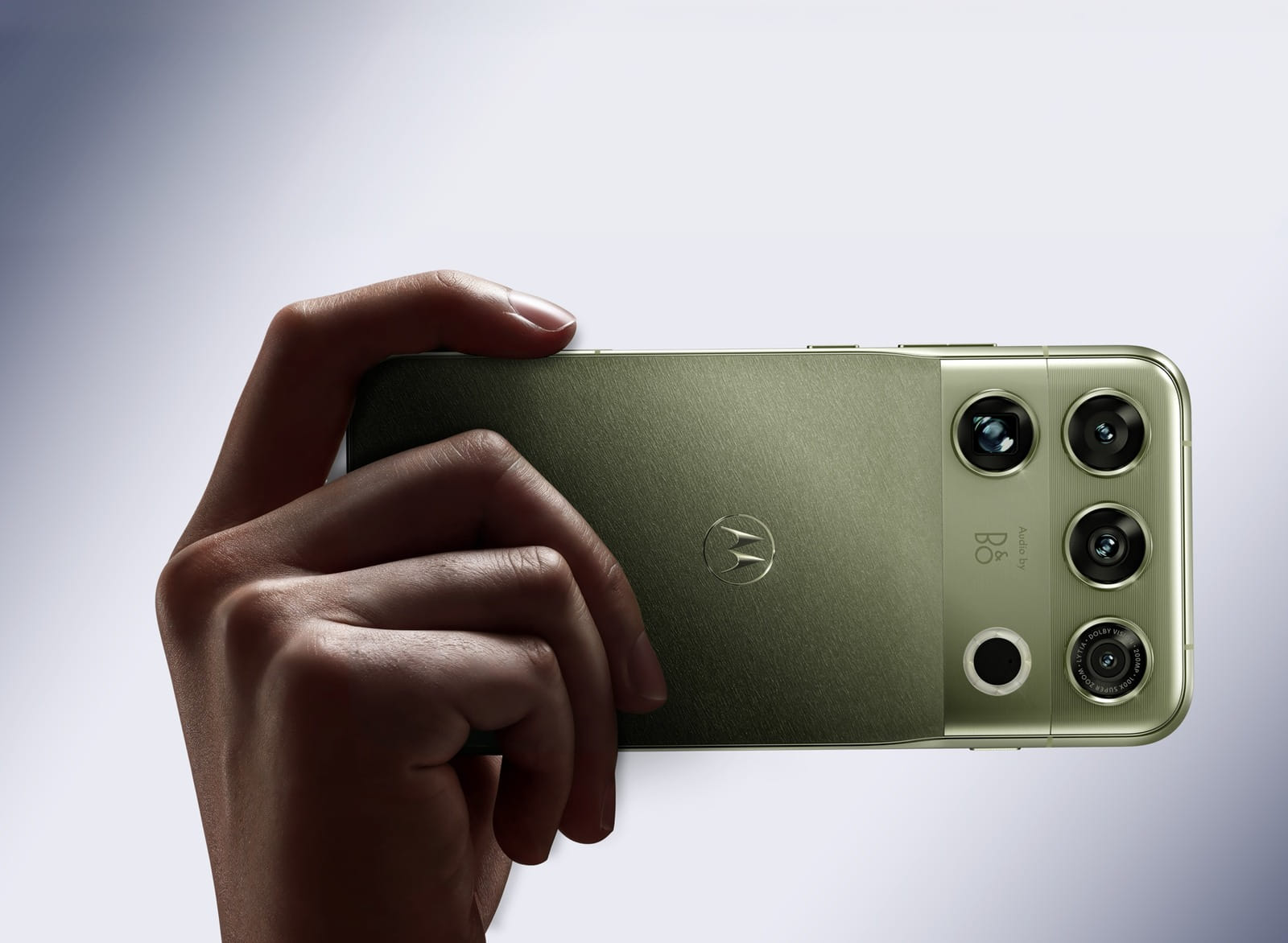 Mão segurando o Motorola Signature 27 verde, com destaque para o módulo de câmeras