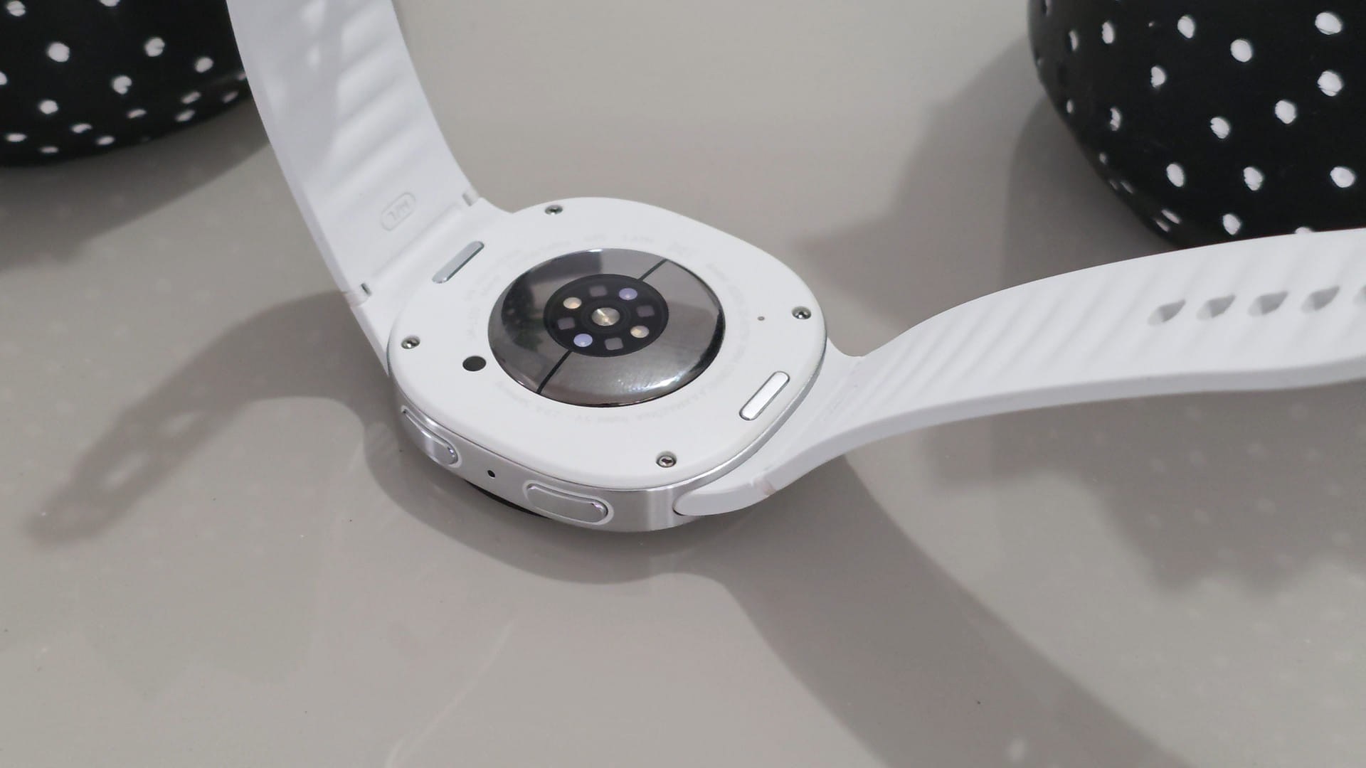 Traseira de um Galaxy Watch branco com o conjunto de sensores ópticos de saúde