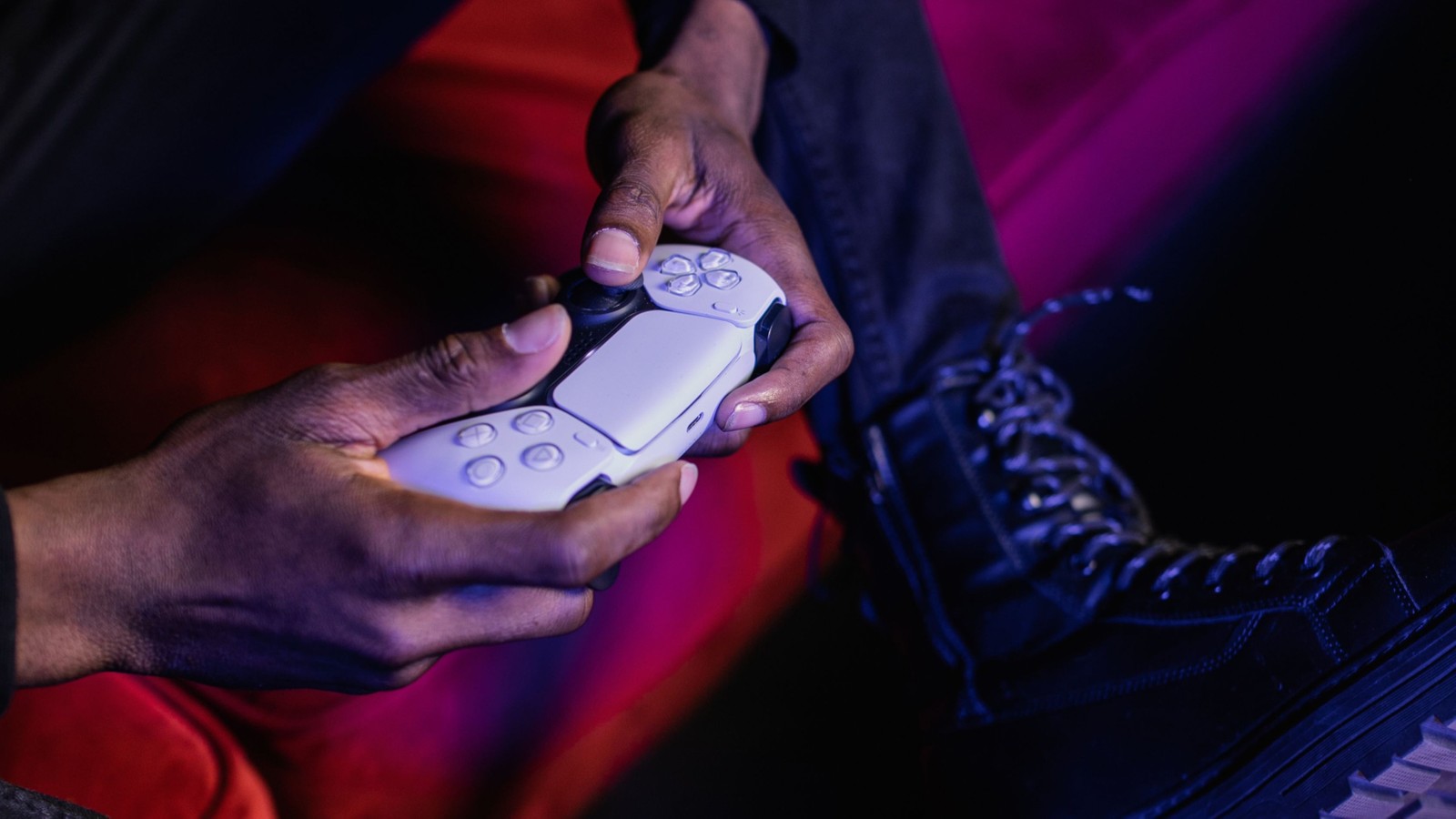 Jogador segurando um controle DualSense do PlayStation 5